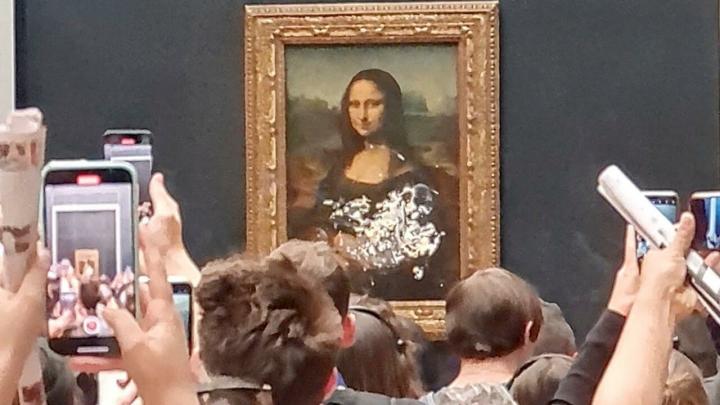 Man disguised as old woman throws cake at the Mona Lisa